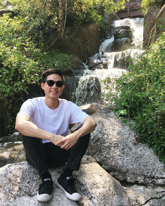 Kevin Chuang sitting beside a waterfall